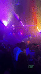 Nightclub scene captured with colorful lighting and crowded dance floor
