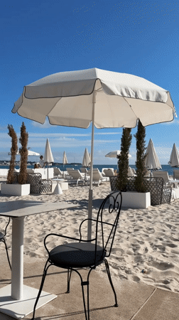 Person spotted at Cannes beachfront amid white umbrellas