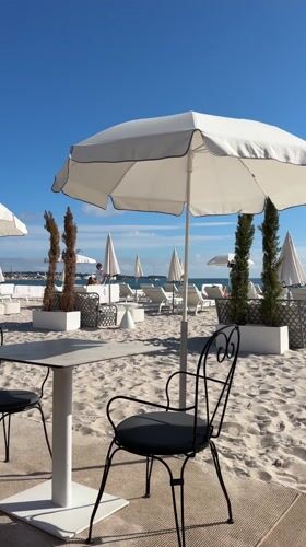 Person spotted at Cannes beachfront amid white umbrellas