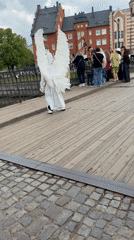 Costumed figure with wings crosses bridge in Kaliningrad