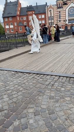 Costumed figure with wings crosses bridge in Kaliningrad