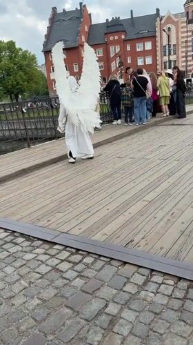 Costumed figure with wings crosses bridge in Kaliningrad