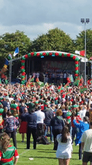 Green and red crowd rallies around a festive stage in Claremorris