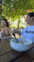 Friends gather for leisurely outdoor brunch in Thai cafe