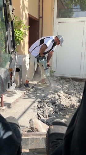 Construction worker jackhammers concrete walkway in Targovishte, Bulgaria