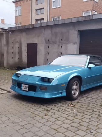 Blue Camaro convertible parked on Tallinn cobblestones