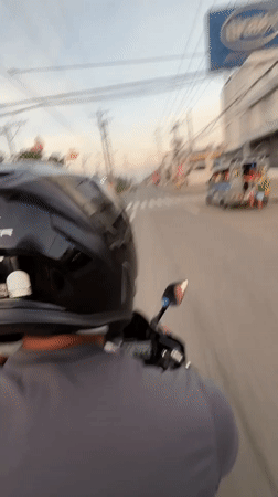 Motorcycle rider navigates evening traffic in Davao City
