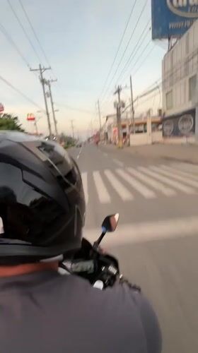 Motorcycle rider navigates evening traffic in Davao City