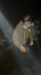 Night hikers navigate steep Indonesian trail with headlamps