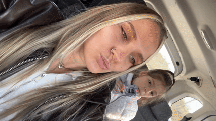 Woman takes selfies in car with child passenger