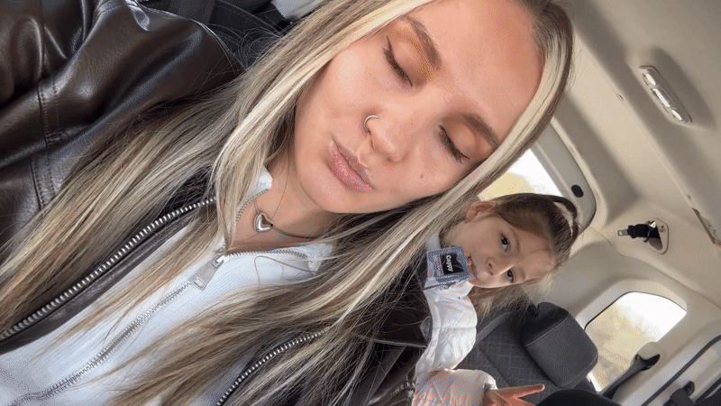 Woman takes selfies in car with child passenger