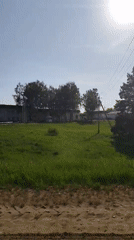 Vehicle travels through rural Russian countryside on sunny day