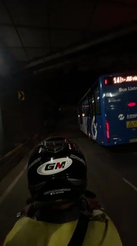Motorcyclist follows Transjakarta bus through Central Jakarta tunnel