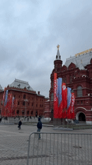 Historic Moscow square features vintage newspaper display near red-brick tower