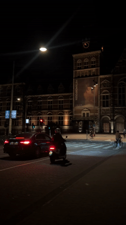 Nighttime Amsterdam street activity documented near Rijksmuseum exhibition