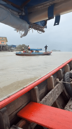 Longtail boat moving through Pak Nam waterways