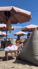 Beachgoers relax under umbrellas in North Kuta, Indonesia