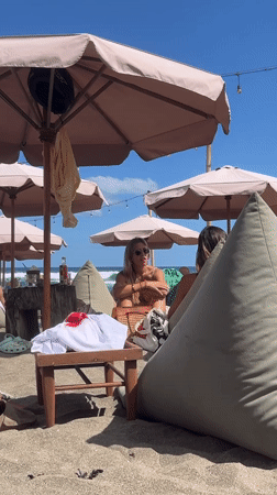 Beachgoers relax under umbrellas in North Kuta, Indonesia