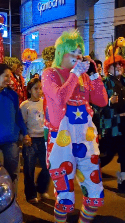Costumed nighttime parade with dragon, clown figures in Arequipa