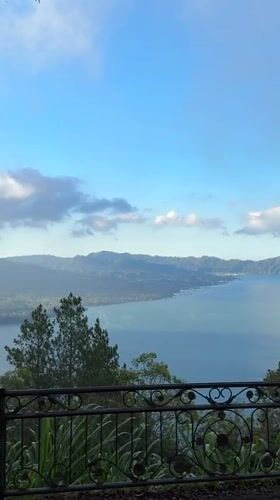 Tourist observes mountain lake vista from Kintamani viewpoint