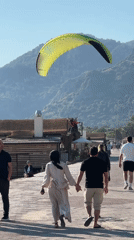 Paragliders land on Fethiye beach as crowds watch