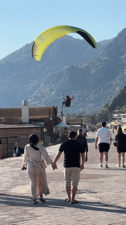 Paragliders land on Fethiye beach as crowds watch