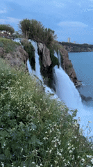 Visitors enjoy Lower Düden Waterfall at dusk in Antalya