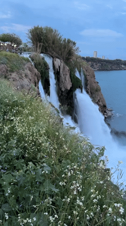 Visitors enjoy Lower Düden Waterfall at dusk in Antalya