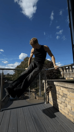 Young man exercises on balcony, takes selfies in London