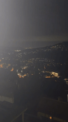 Nighttime aerial over Corbera de Llobregat's valley lights