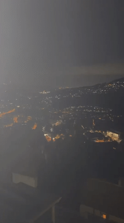 Nighttime aerial over Corbera de Llobregat's valley lights