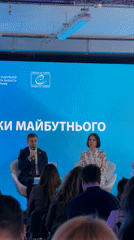 Conference panel features man and woman on stage