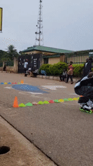 Inline skaters navigate cone obstacle course on Jos street