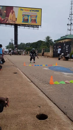 Inline skaters navigate cone obstacle course on Jos street