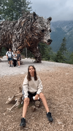 Driftwood bear sculpture and alpine meadows in Molveno