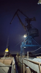 Night crane operations load material onto barge in Tver