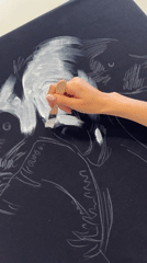 Artist applies white paint to black canvas in Krasnoyarsk
