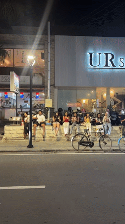 Young adults gather near gelato shop in nighttime Denpasar