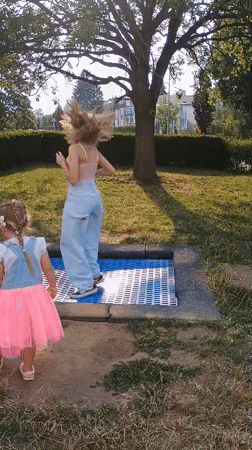Afternoon park play around a trampoline in Sokolov, Czechia