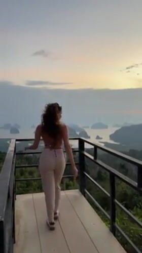 Woman poses on scenic viewing platform in coastal Thailand