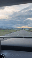 Woman drives through rural Bulgaria amid dramatic skies