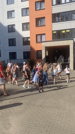 Kids and adults gather in a sunny Minsk apartment courtyard
