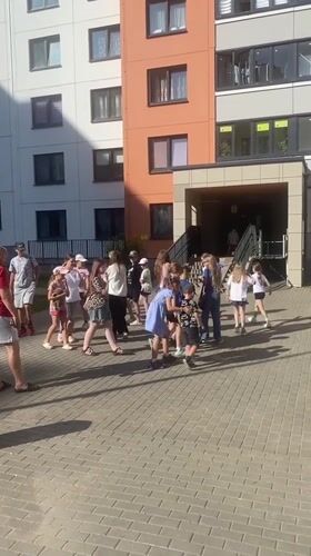 Kids and adults gather in a sunny Minsk apartment courtyard