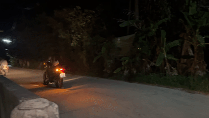Motorcycles travel past local shop in Koh Phangan Thailand