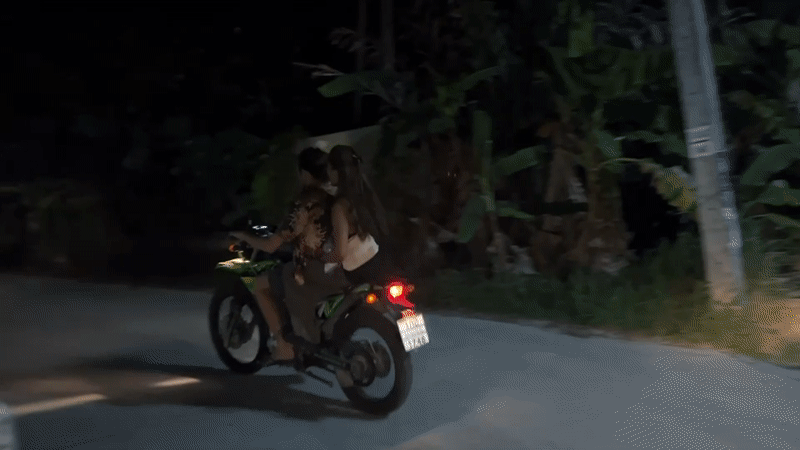 Motorcycles travel past local shop in Koh Phangan Thailand