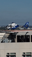 Medical helicopter parked on Sacramento rooftop helipad, doors open.