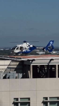 Medical helicopter parked on Sacramento rooftop helipad, doors open.