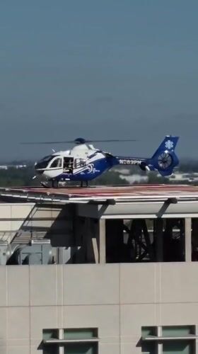 Medical helicopter parked on Sacramento rooftop helipad, doors open.