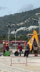 Construction crew operates heavy machinery at Thai worksite