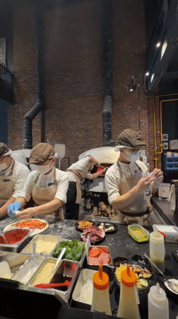 Pizza prep underway in a Đà Nẵng commercial kitchen